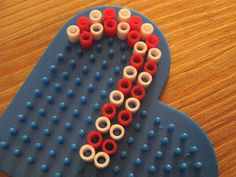 an object made out of plastic beads on top of a wooden table