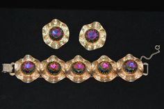 Vintage set consisting of large clip-on earrings and a bracelet. Set refers to the 60s of the last century. Made in golden tone metal with unusually beautiful large round crystals that play with multi-colored colors from pink yellow blue and green. Such crystals are called watermelon. The bracelet consists of five sections, each section carries a similar crystal, which in addition is decorated with small bust-colored crystals. each section has a curved shape with a structured surface. The bracel Retro Gold Clip-on Earrings For Party, Gold Retro Clip-on Earrings For Party, Retro Gold Bracelets For Party, Retro Gold Party Bracelets, Collectible Retro Clip-on Jewelry, Retro Evening Clip-on Jewelry, Mid-century Gold Clip-on Earrings For Party, Gold Mid-century Clip-on Earrings For Party, Watermelon Bracelet