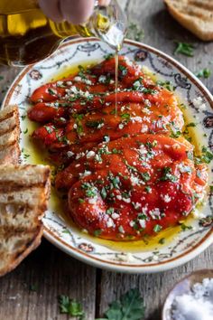 someone is pouring sauce on some bread with garlic and parmesan sprinkles