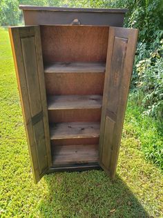 an old wooden cabinet sitting in the grass