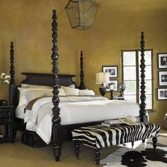 a bed room with a neatly made bed and zebra rug