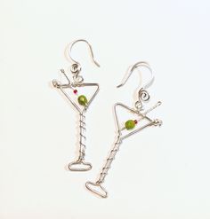 "Fun martini glass earrings ..now with improved more realistic beads for the olive...I used 4mm green faceted oval shape beads.  These also have a better earhook placement in the center so they hang straight not tilted.    The silver wire is 18 gauge silver plated non tarnish.  Drop length is 2.25\".  Your choice of silver or goldplate too. *If ordered as a gift it will come in a box as shown.  Just added a new variation of Espresso martinis! ..with brown bronzite beads and white faux pearls beads.  Now available you can order the necklace.. pendant martini with chain.   Chain is 20\" stainless steel.  Gold chain is goldplate. * I also have many other beverage party earrings too ! : Champagne : https://www.etsy.com/listing/1380883157   Margarita: https://www.etsy.com/listing/1557159350/ Wi Wire Wrapped Silver Plated Ring For Party, Green Wire Wrapped Jewelry For Party, Wire Wrapped Czech Glass Jewelry For Party, Party Glass Jewelry Wire Wrapped, Party Wire Wrapped Glass Jewelry, Funky Earrings Diy, Martini Earrings, Weird Earrings, Espresso Martinis