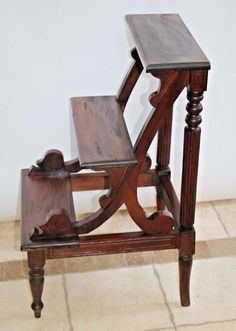 an old wooden chair sitting on top of a tiled floor