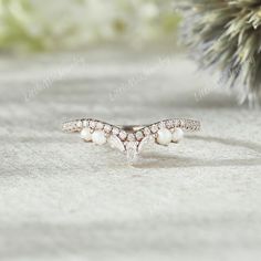 a close up of a ring with pearls on it