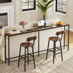 a living room filled with furniture and a laptop computer on top of a wooden table