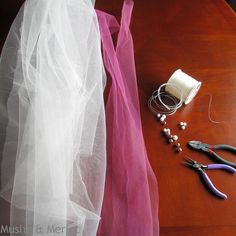 the table is covered with various crafting items including scissors, beads and tulle