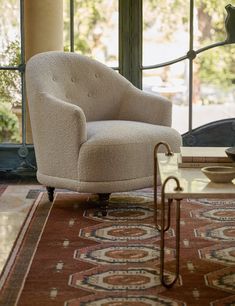 a chair sitting on top of a rug next to a window