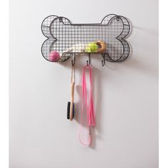 a dog bone shaped wall hanging on the side of a wall with hair brushes and combs attached to it