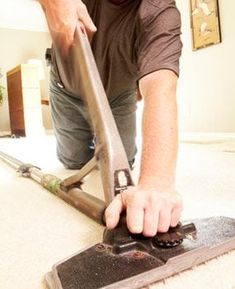 a man is cleaning the floor with a vacuum