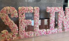 the letters are made out of flowers in front of a wall that says pepo