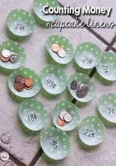 a bunch of money sitting on top of a table next to some paper cupcake liners