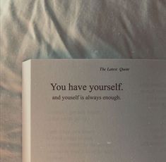 an open book sitting on top of a bed next to a white sheet with the words you have yourself and yourself is always enough