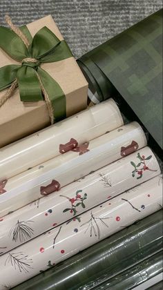 wrapping paper wrapped in green ribbon and tied up with a bow, sitting next to a present box