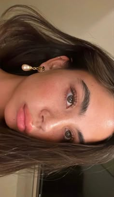 a woman with long brown hair is looking at the camera and has her eyes closed