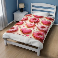 a bed topped with pink donuts covered in sprinkles next to a night stand