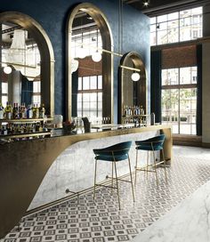 an elegant bar with marble counter tops and stools