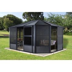 a black gazebo sitting on top of a lush green field