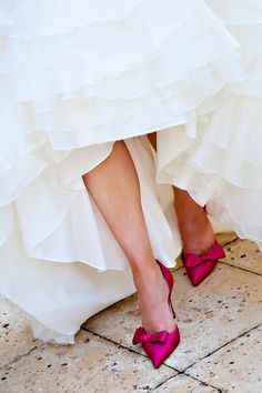 the bride's feet are wearing pink high heels