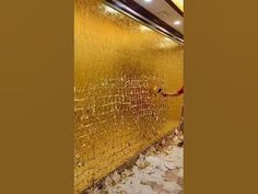 a man is painting a wall with gold paint on the outside and inside of it