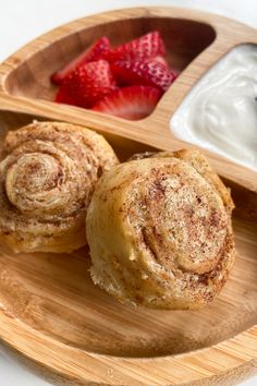 cinnamon rolls and strawberries on a wooden plate