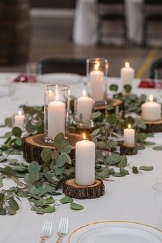 the table is set with candles and greenery