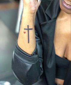 a woman with a cross tattoo on her wrist