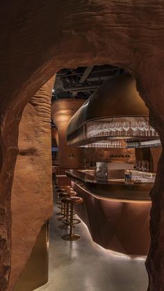 the interior of a bar with wooden stools and bars on either side of it