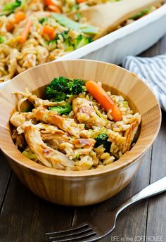 two bowls filled with rice and vegetables on top of a wooden table