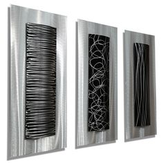 three metal art pieces hanging on a wall