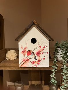 a bird house sitting on top of a wooden shelf