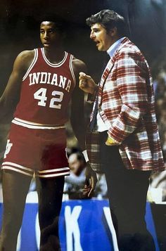 an old photo of two basketball players talking to each other