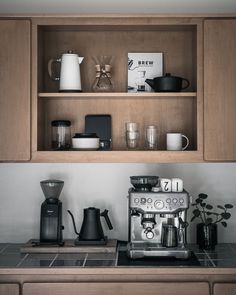 a coffee maker and some cups on a counter