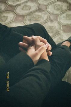 two people holding hands while sitting on the floor