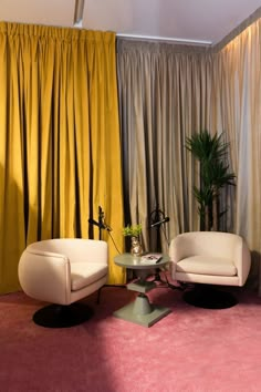 two white chairs sitting next to each other on top of a pink carpeted floor