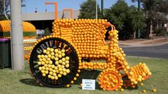 an orange truck made out of lemons on display in front of a street sign