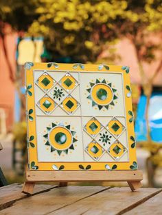 a yellow and white tile stand on a wooden table