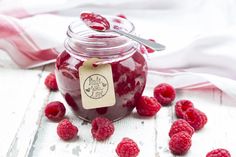 raspberry jam in a glass jar with spoon