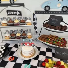 a table topped with cakes and cupcakes on top of checkered tables cloth