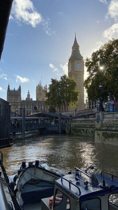 two boats are docked in the water next to a bridge with a clock tower on it