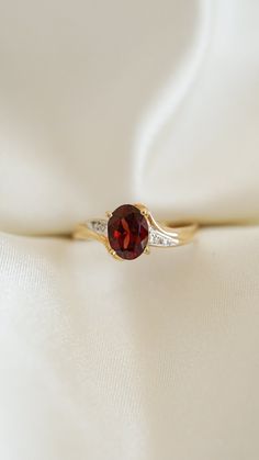 * Ring Material: Garnet, Diamond, 14K Yellow Gold  * Ring Dimensions:17.8x13 MM, 2.8MM Tapering Band  * Size: 6.75 * Stone Weight & sizes: Garnet - 1.30ct, Diamond - 0.04ct  * Overall weight: 2.1g Dark Red Ring, Engagement Rings Garnet, Vintage Garnet Rings With Accent Stones, Vintage Garnet Ring With Center Stone, Demantoid Garnet Ring, Heirloom Gold Garnet Rings, Elegant Red Garnet Diamond Ring, Garnet Rings With Polished Finish - Fine Jewelry, Rhodolite Garnet Ring