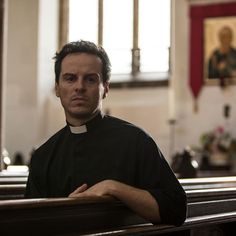 a man standing in the pews of a church with his arms folded out and looking at the camera