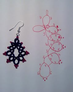 two pairs of earrings are shown next to each other on a white surface with red and black designs