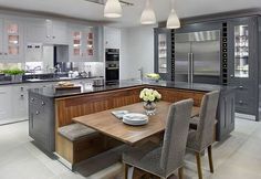 a modern kitchen with an island table and chairs