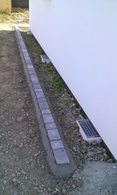 a white building with a brick walkway next to it and an air conditioner on the side