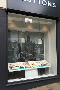 a store front with an assortment of items displayed in the window and below it is a sign that says cottons