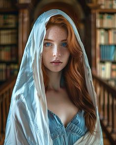 a woman with red hair and blue eyes wearing a white shawl in front of bookshelves