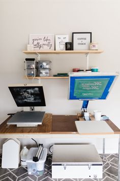 a desk with two computers on it and some shelves above the desk that hold books