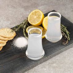 lemons, salt and pepper shakers on a cutting board next to crackers