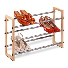 three pairs of shoes are sitting on a metal and wood shoe rack that holds four pairs of shoes