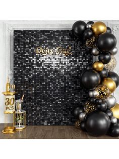 a black and gold party backdrop with balloons